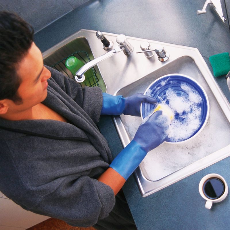 Washing dishes at a kitchen sink